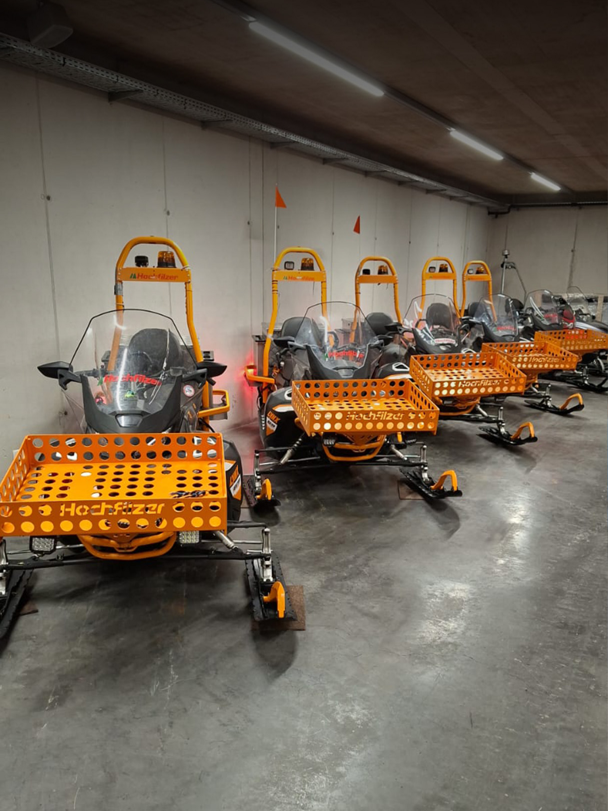 Orange, schwarze Lynx Motorschlitten mit Hochfilzer-Aufklebern auf der Windschutzscheibe.