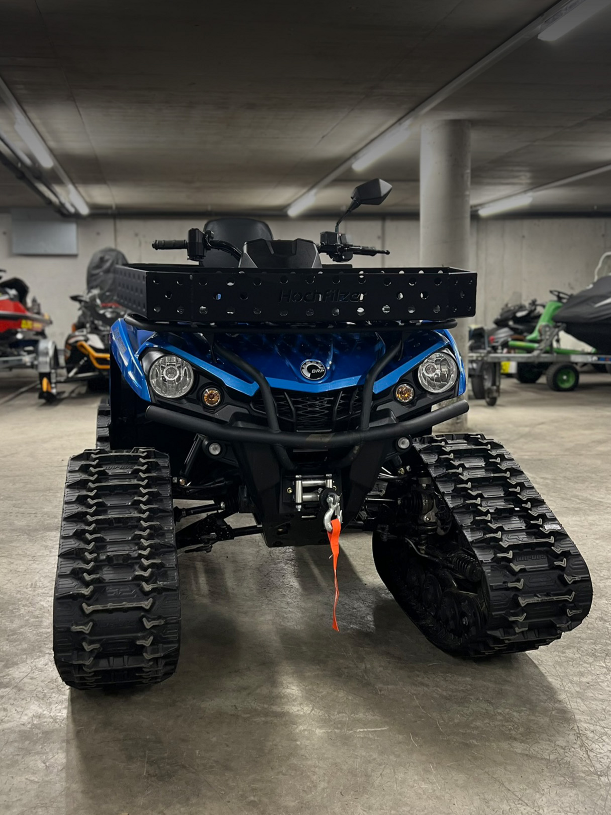 Blaues Can-Am ATV mit Raupenaufbau.